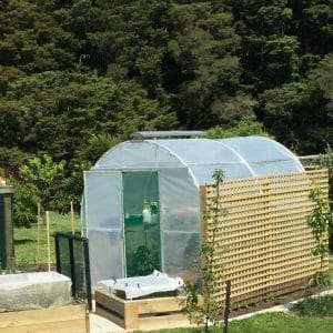 Duratough Tunnel House with additional roof vent in garden with trees in the background.