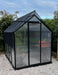 2m x 2.6m polycarbonate greenhouse shown in a garden sitting on white pebbles with shade cover accessory on top. 